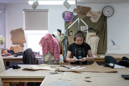 A woman is surrounded by pattern drafts.